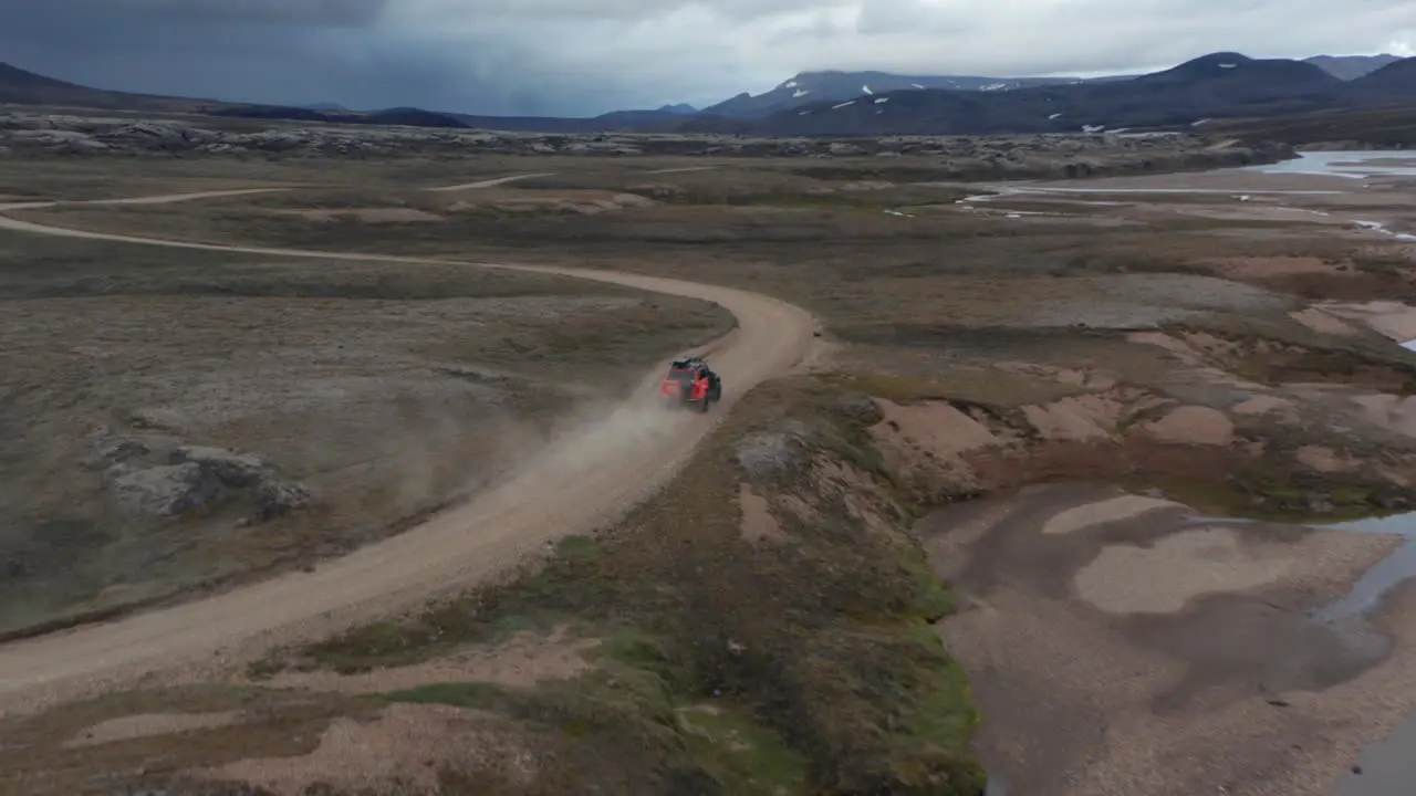 Birds eye view off road jeep driving in wild landscape Iceland Aerial view 4x4 vehicle speeding traveling across mossy and desert icelandic countryside Adventure and exploring Travel destination