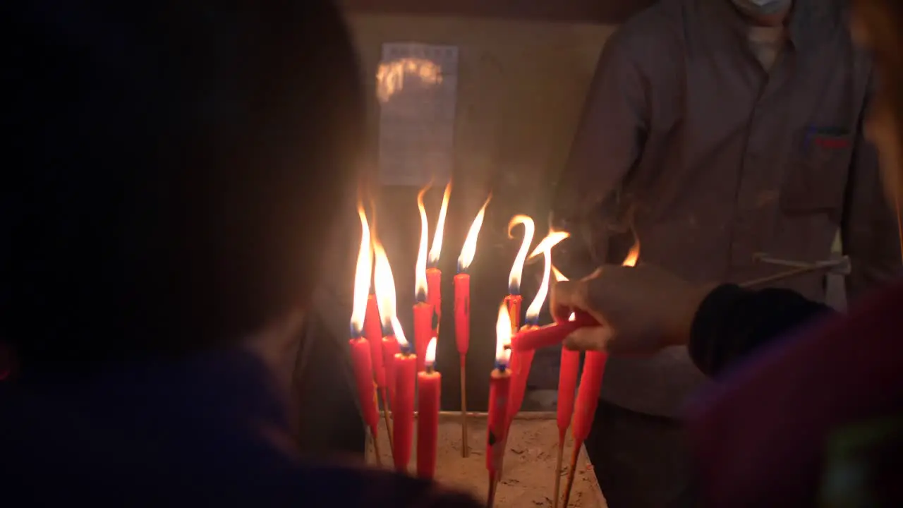 People Lighting Candles in Man Mo Temple