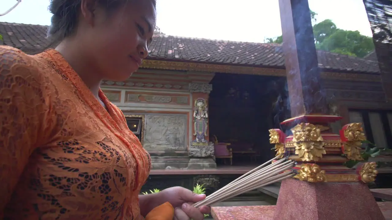 Woman Burns Incense in an Indonesian Temple