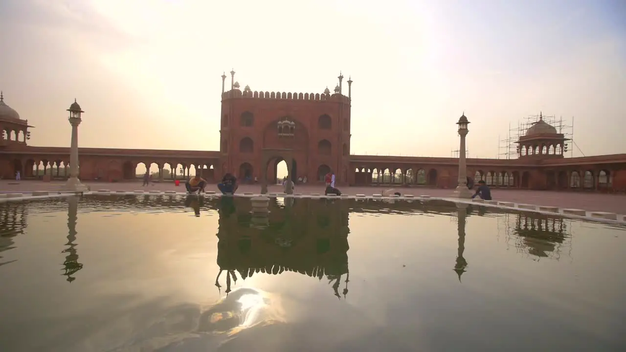 Tracking Shot Past People Cleaning at Temple