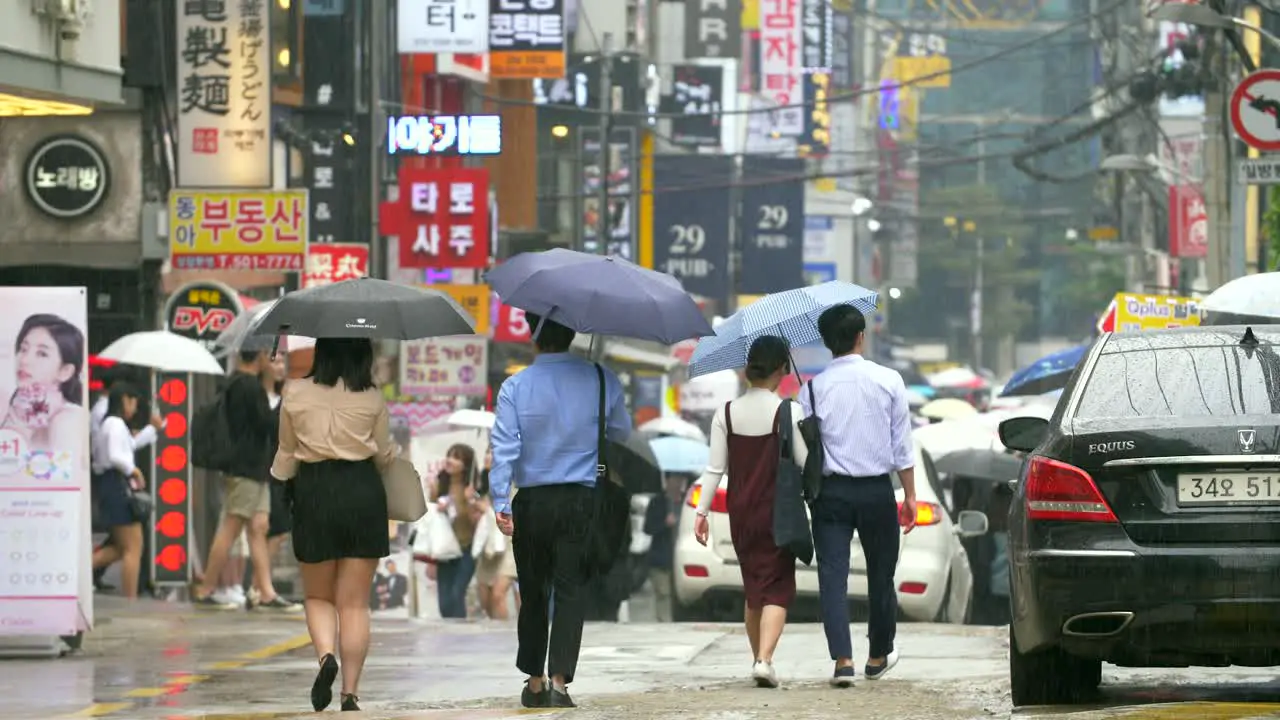 People Walking Down Wet Seoul Street