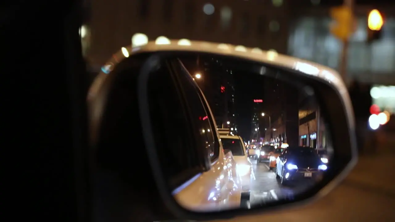 Car driving through urban city looking through rear view mirror