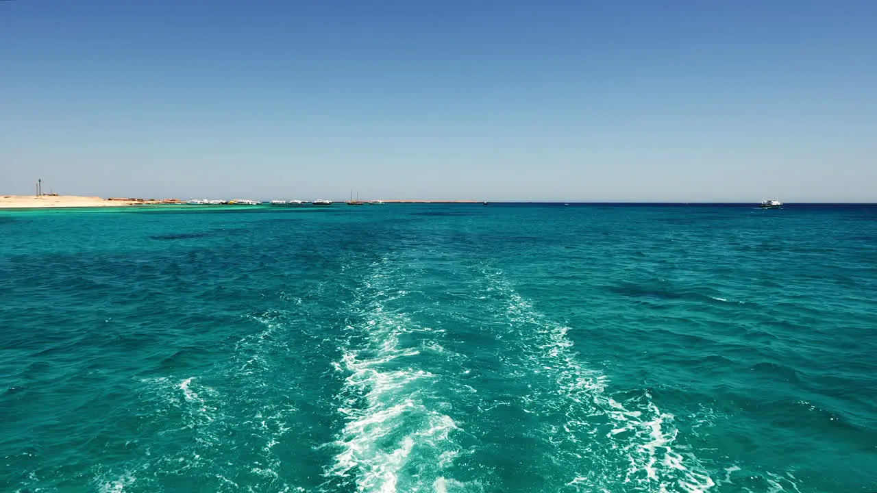 Seascape Boat Rear View Sailing on Turquoise Sea Water By Coast in Summer Day Orange Bay Region Hurghada Egypt Waterfront Coastal View