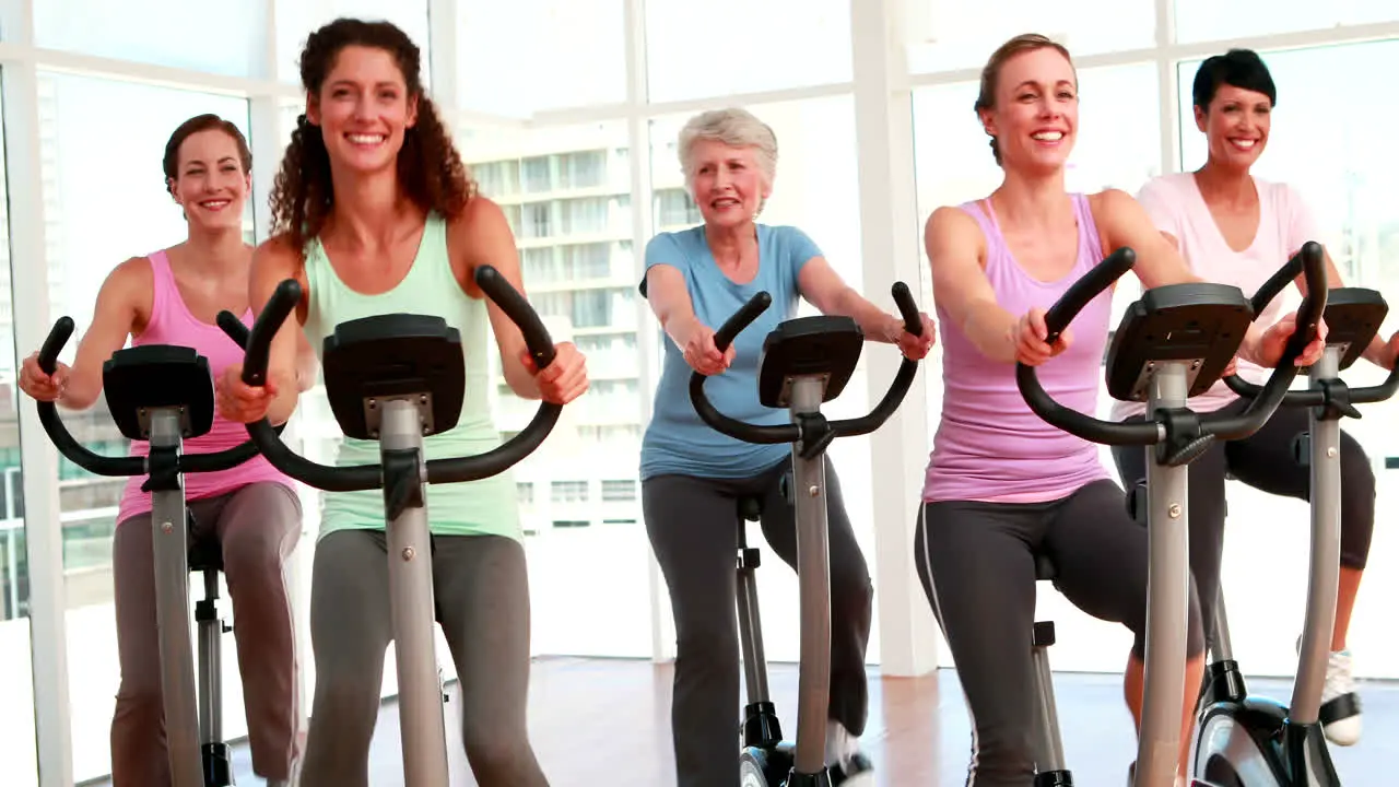 Group of smiling women in doing a spinning class