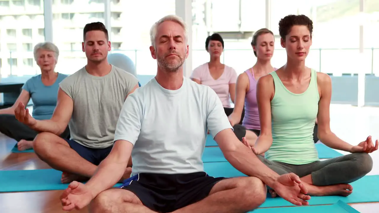 Yoga class sitting in lotus position together