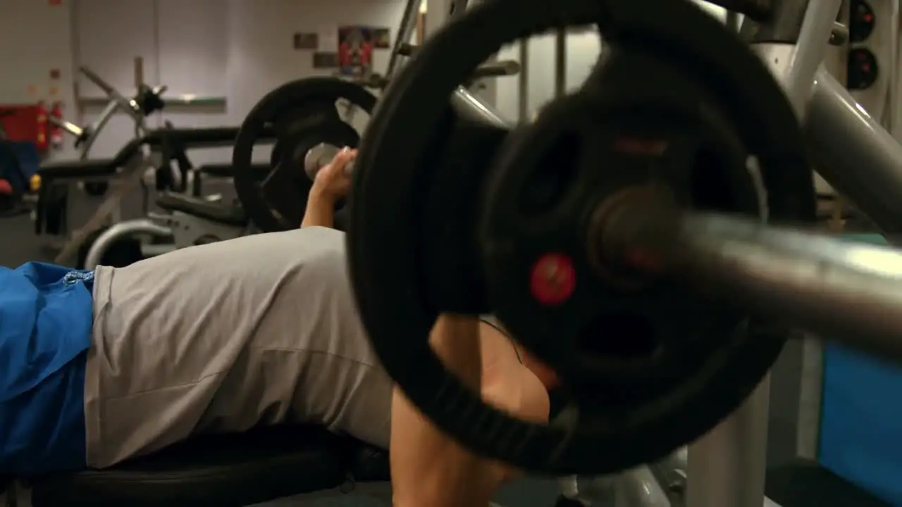 Man lifting heavy barbell at gym