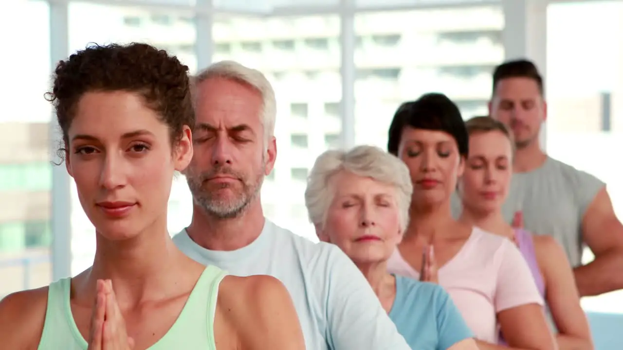 Yoga class standing with eyes closed