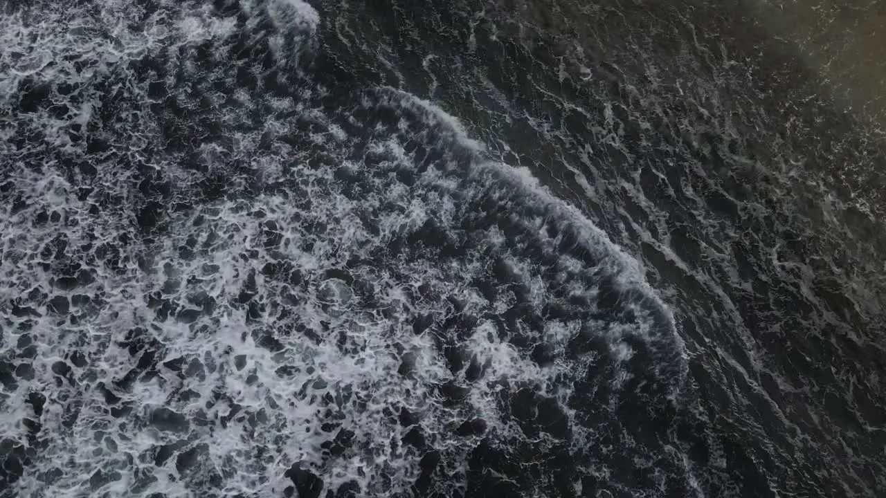 A bird's eye view footage of the open waters with various waves and sea foam