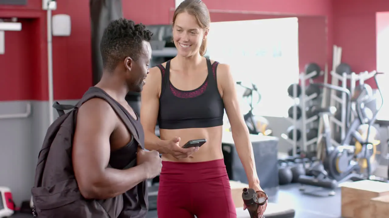 Fit African American man and young Caucasian woman at the gym