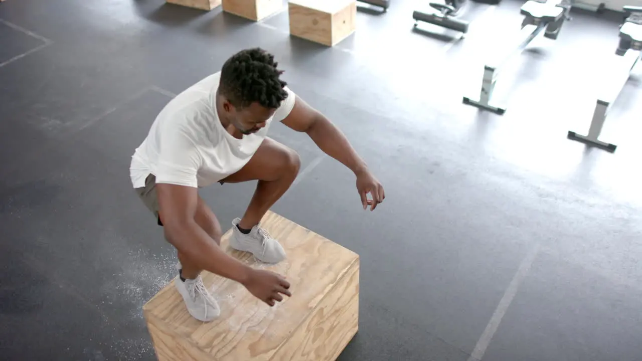 Fit African American man performs a step-up exercise at the gym