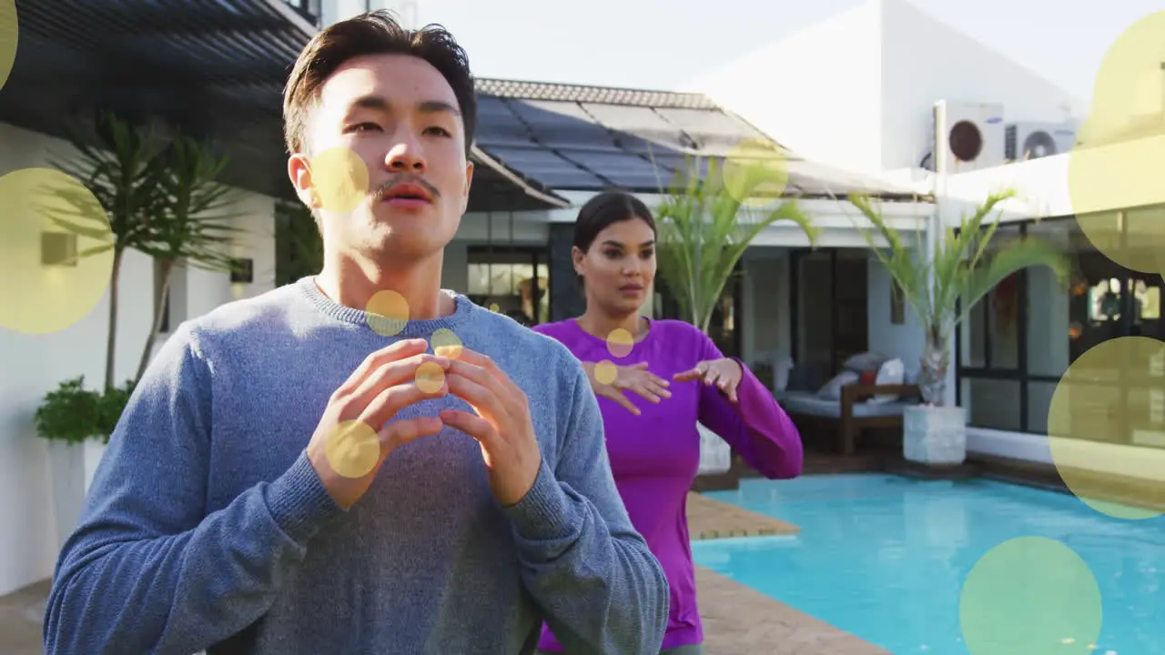 Animation of spots of light over diverse couple exercising by swimming pool at home