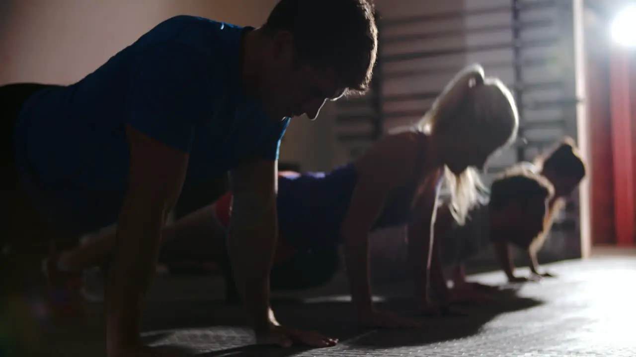 Four people doing press ups at a gym