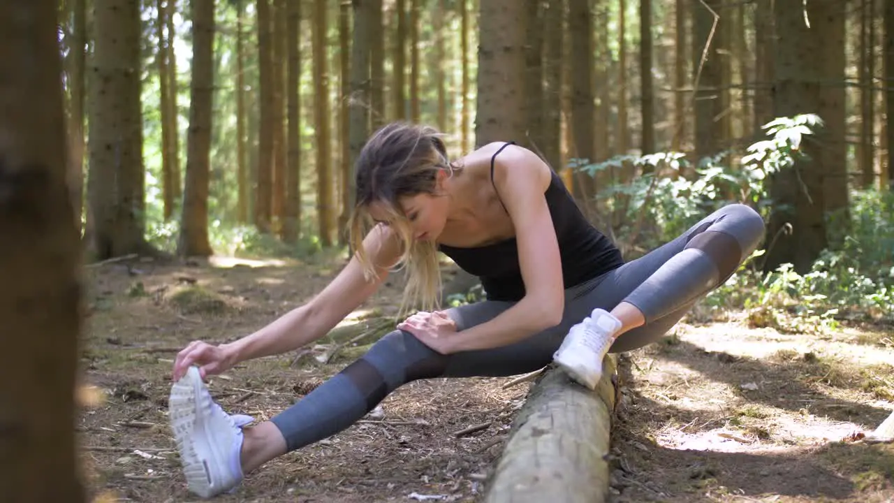 Slow motion view of a pretty woman stretching her legs as she prepares for a run