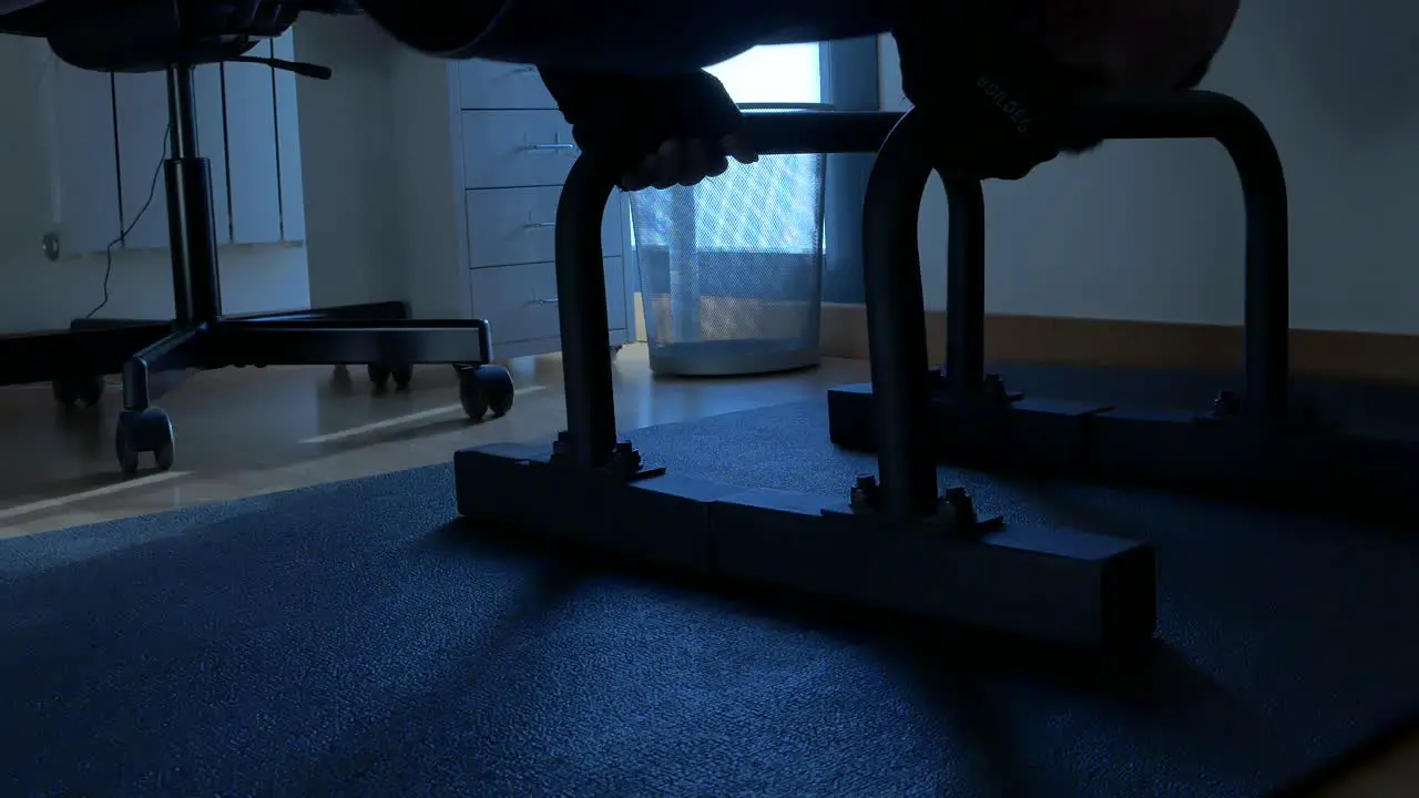 A close up shot of push bars with a man doing push ups on them