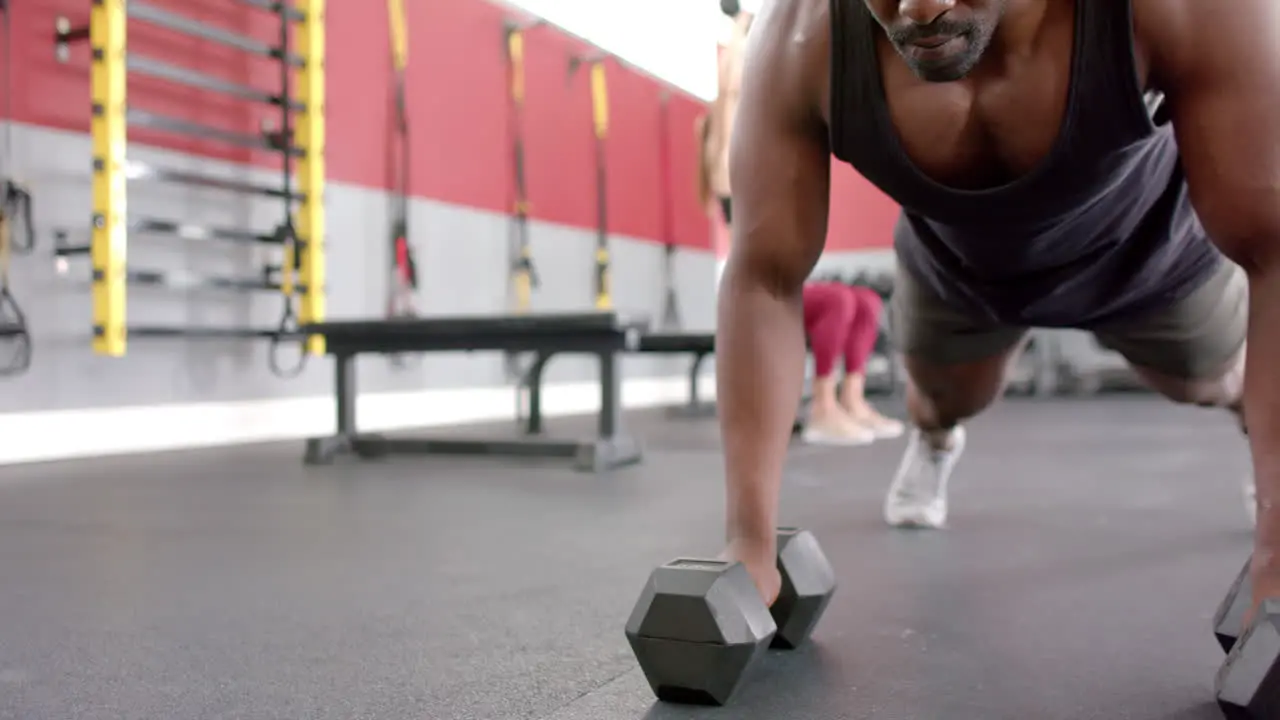 Fit African American man lifting weights at the gym