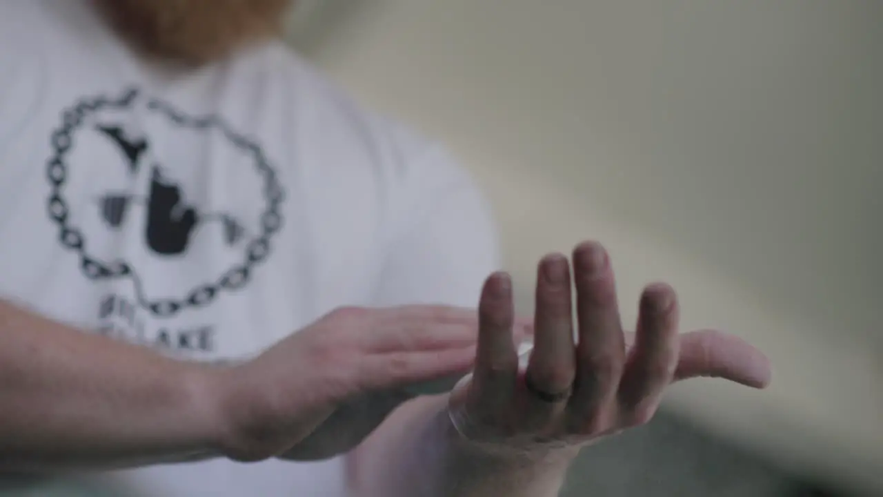 Caucasian Weight Lifter Putting On Grip Chalk Before Workout Close Up