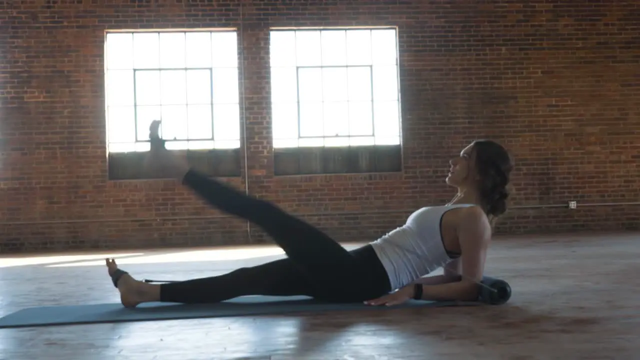 female fitness actress performing pilates exercises on yoga mat