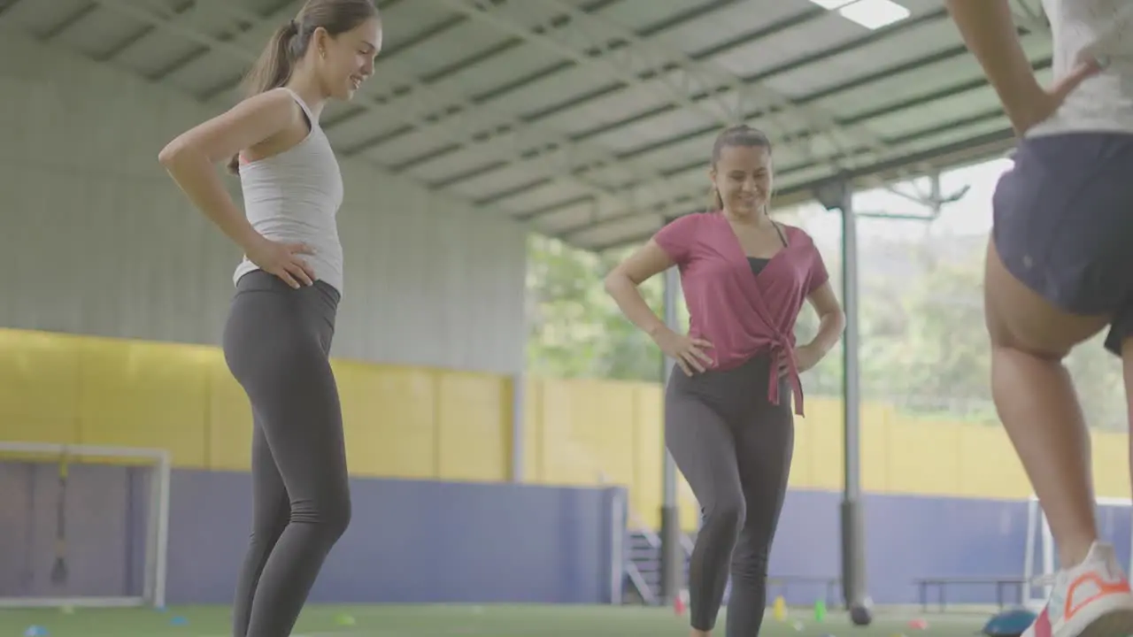 chicas utilizando ligas elasticas para ejercicio con los pies sobre zacate verde y tennis blancas