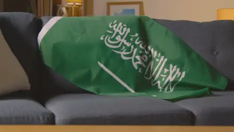 Flag Of Saudi Arabia Draped Over Sofa At Home Ready For Match On TV 2