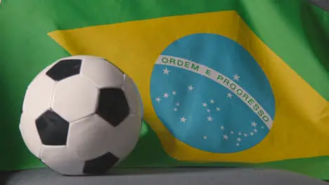 Flag Of Brazil Draped Over Sofa At Home With Football Ready For Match On TV 2