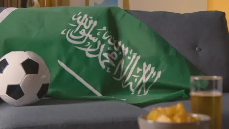 Flag Of Saudi Arabia Draped Over Sofa At Home Ready For Match On TV 1