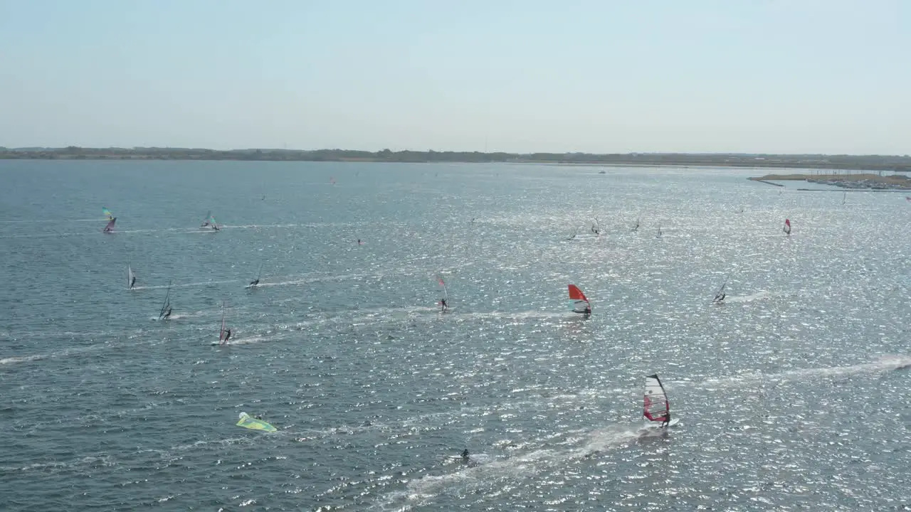 Drone Aerial shot of many surfers on a blue wavy and windy sea on a sunny day with white clouds on a island Zeeland Netherlands 30p