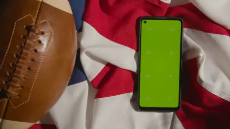 Overhead Studio Shot Of American Football On Stars And Stripes Flag With Green Screen Mobile Phone