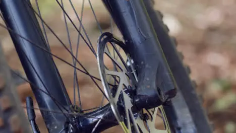 Close Up Of Brake Disc On Wheel Of Mountain Bike On Woodland Trail