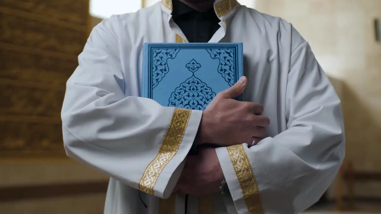 Muslim mosque imam hugs Quran tight to his chest