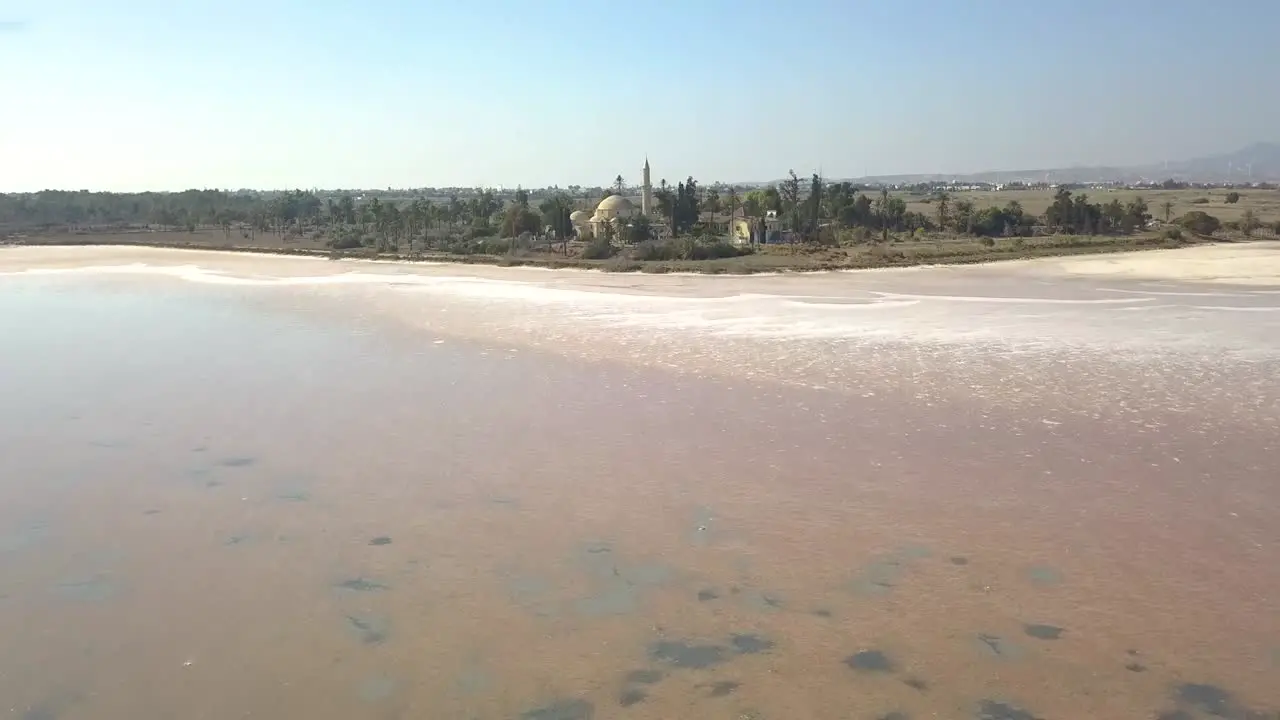 Aerial Tilt Shot Revealing Historical Sultan Hala Tekke Mosque On Beautiful Salt Lake  Larnaca City  Cyprus