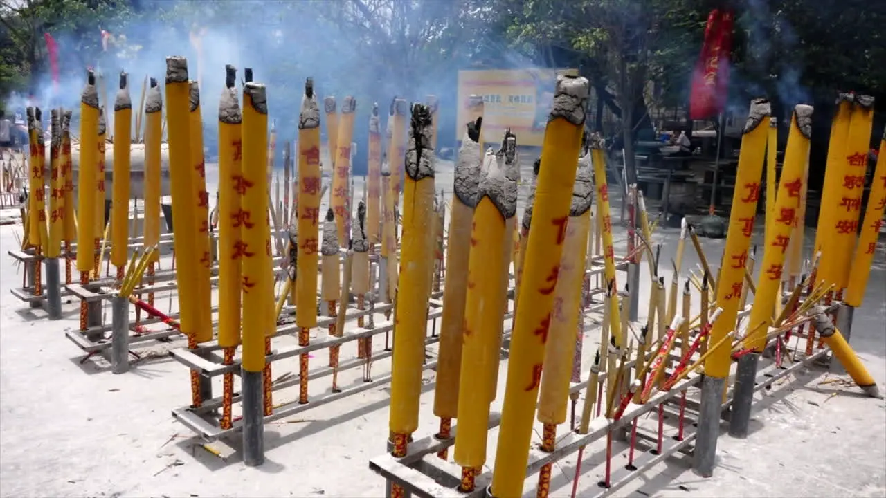 Buddist candles burning in the day at a temple