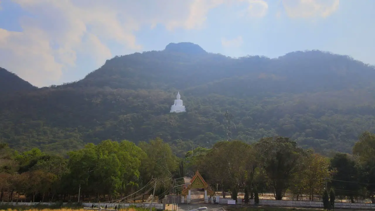 Luang Por Khao Wat Theppitak Punnaram descending aerial footage of the famous white temple on the mountain revealing the arch gate street lights road going inside landscape as a whole