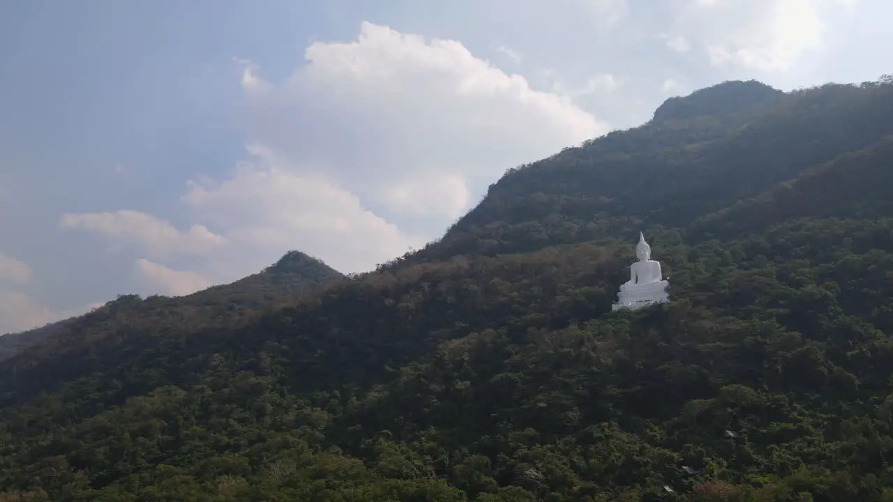 Luang Por Khao Wat Theppitak Punnaram descending aerial 4K footage of the famous Giant White Buddha on a mountain side in Pak Chong Nakhon Ratchasima in Thailand