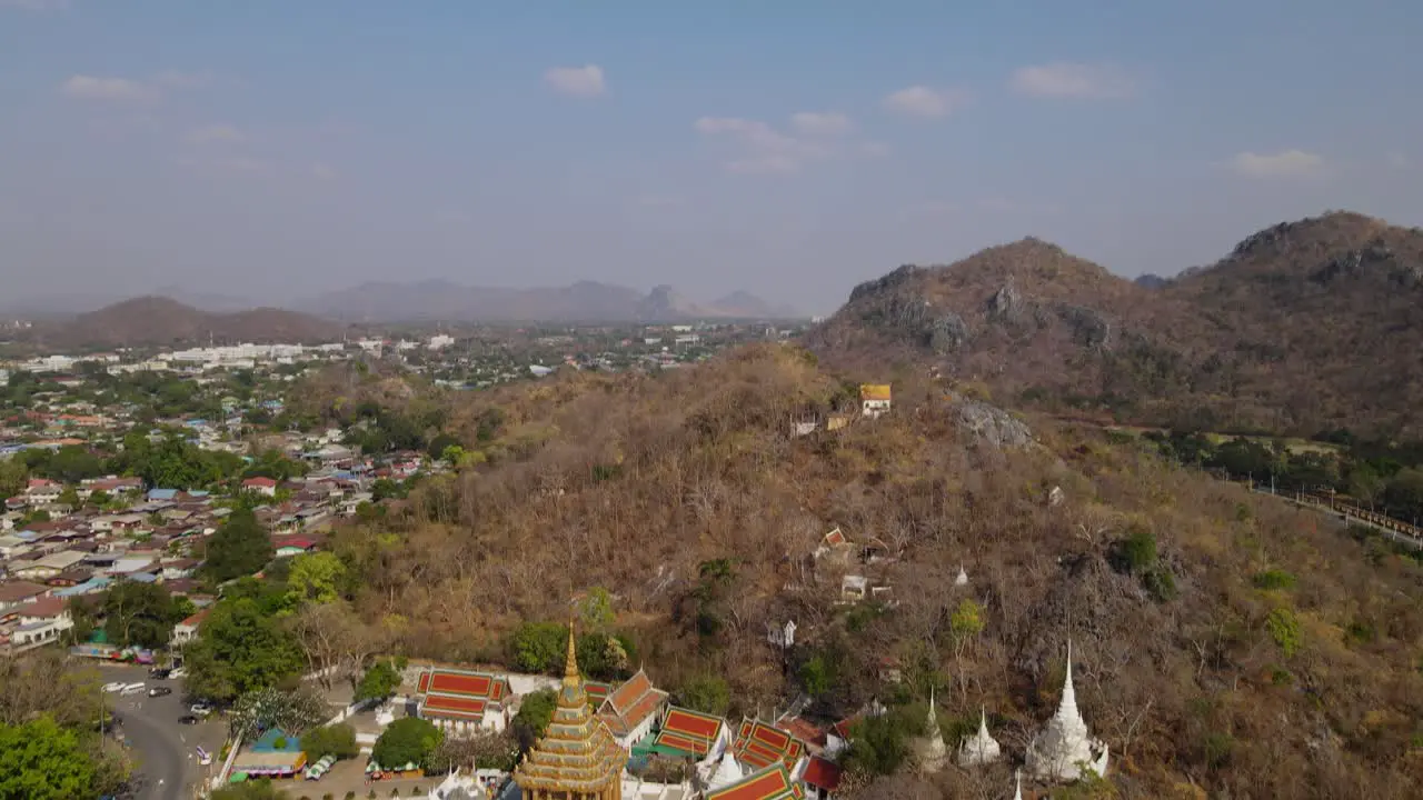 Wat Phra Phutthabat Saraburi Thailand 4k aerial tilt footage from the temple complex to the the horizon revealing a road on the left side communities and limestone hills