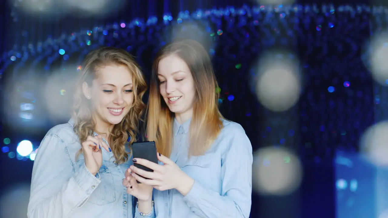 Two Young Women Use A Smartphone And Have A Good Time 2