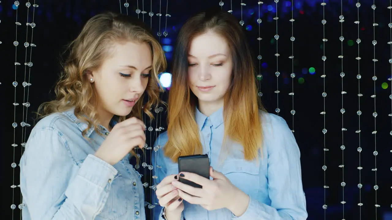 Two Young Women Use A Smartphone And Have A Good Time