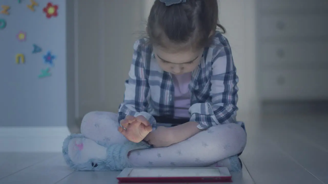 Girl with tablet sitting on floor