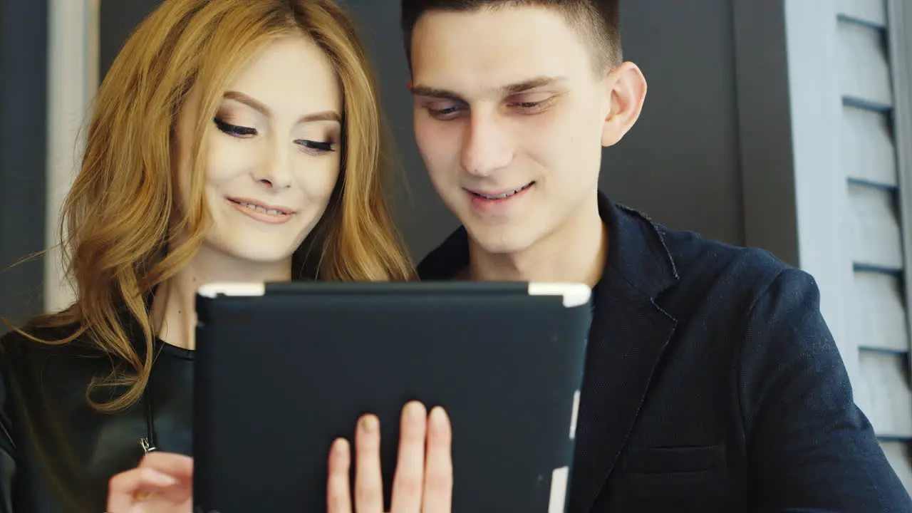 Man And Woman 20-25 Years Use The Tablet In Cafe Smiling