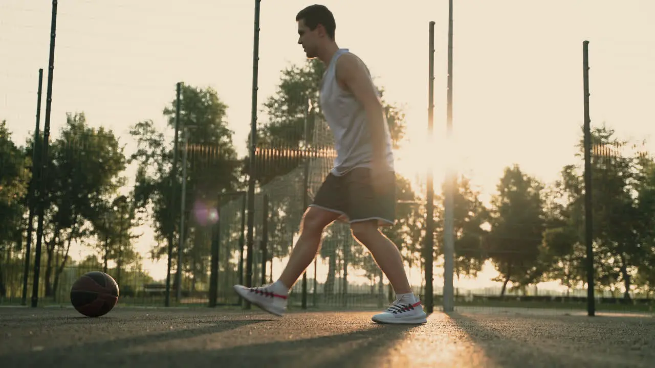 Male Basketball Player Stretching His Legs In An Outdoor Basketball Court