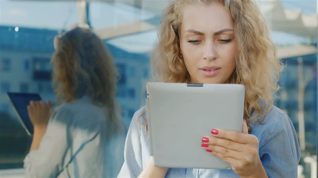 Portrait Of An Attractive Young Woman Uses Tablet Near The Mirror Wall Positive Emotions