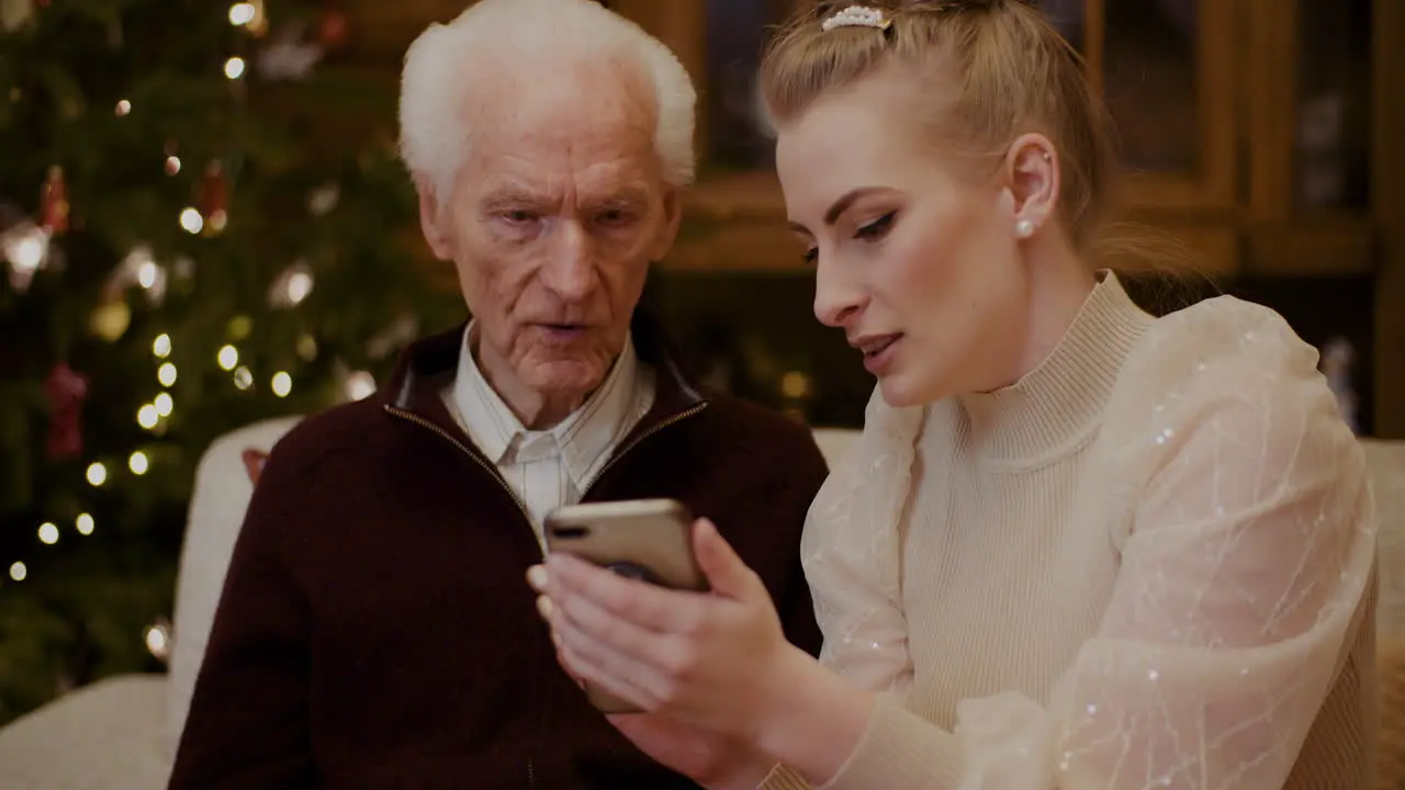 Woman Teaching Grandfather To Use Cellphone In Christmas 1