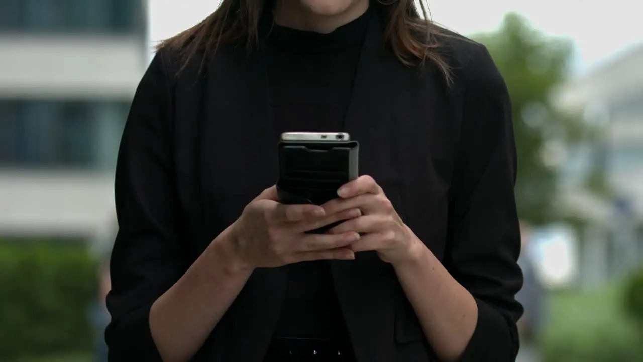 Simple close up view of a young women using her mobile device in a clean modern urban setting