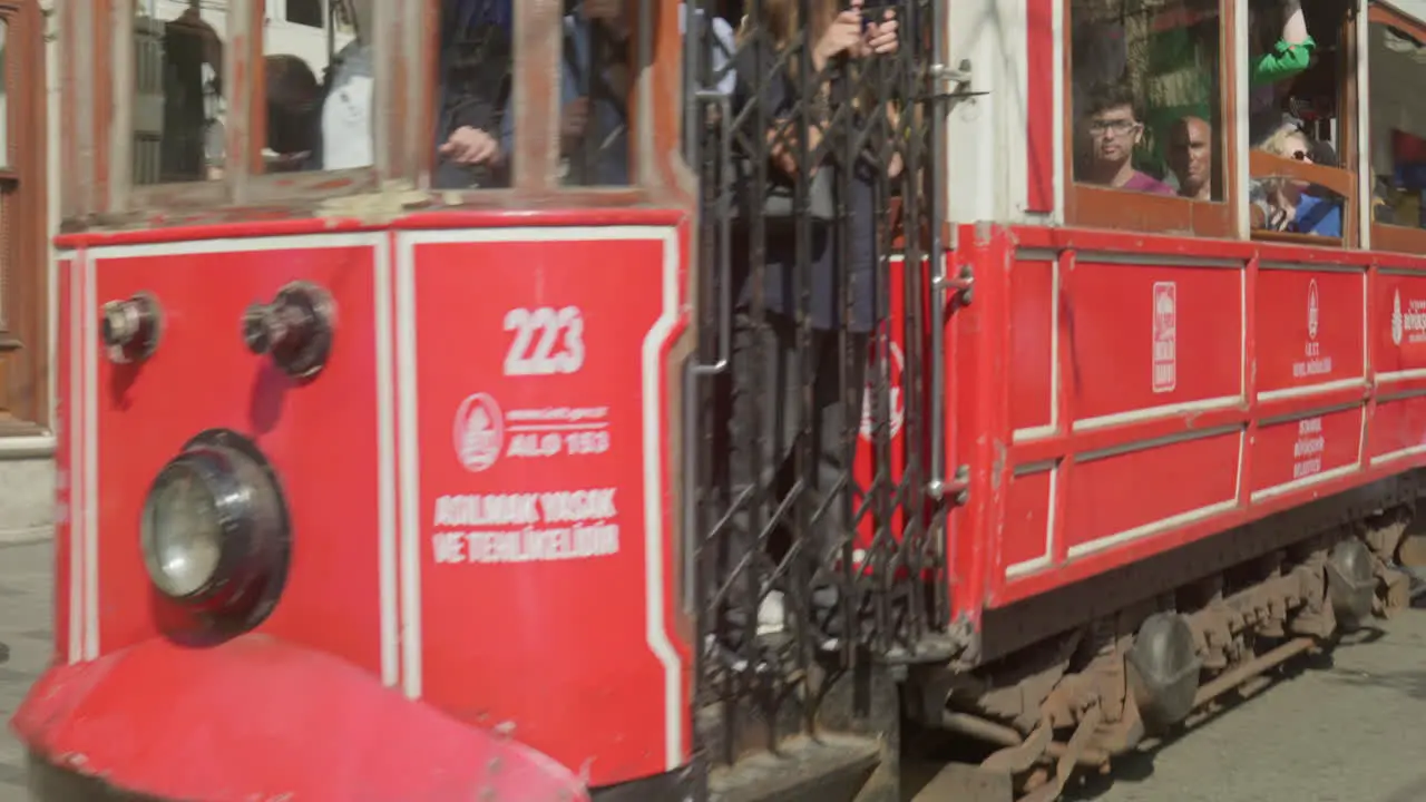 Passengers ride Istiklal Caddesi iconic electric red Tram Istanbul