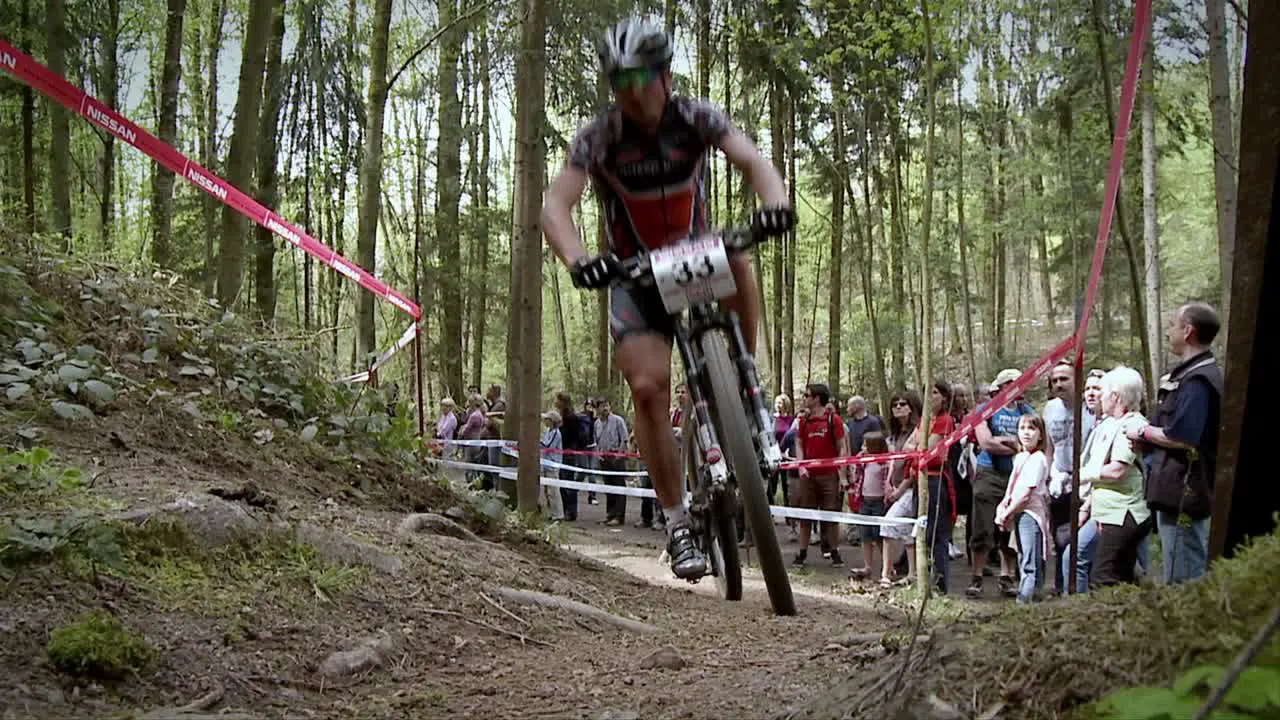 A cyclist races up a rough dirt road course