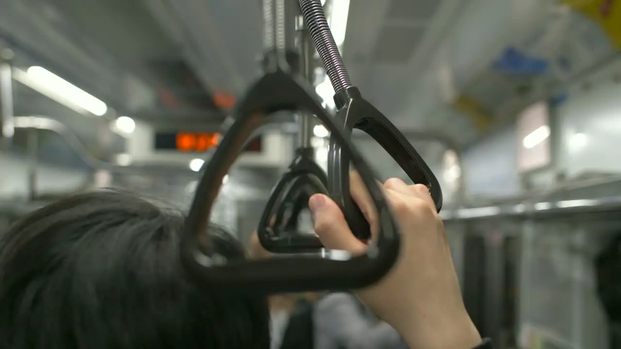 Man Holding Handrail on Train