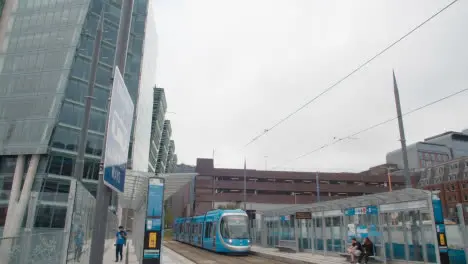 Tram Arriving At Station Stop Platform And Tramway Warning Sign In Birmingham UK