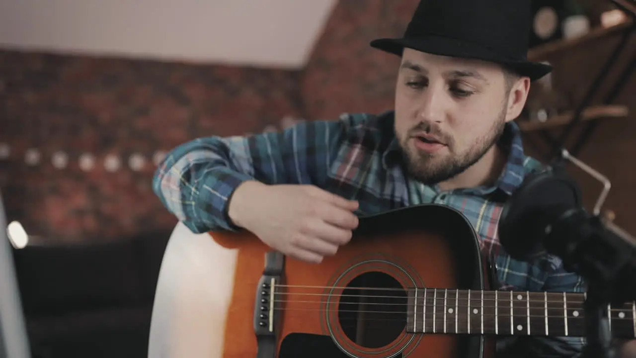 Young Male Musician Recording And Streaming A Video Tutorial Playing Guitar At Home