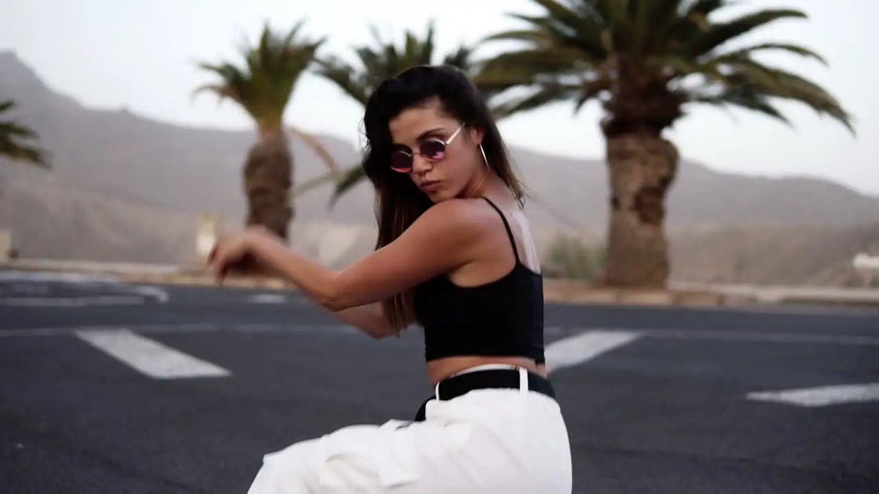 Girl In White Is Dancing Outdoor At The Road With Tropical Trees And Hills On Background 1