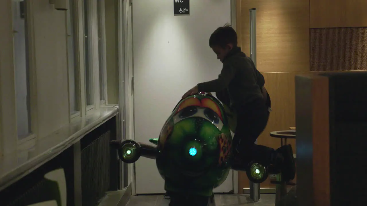 Child riding amusement plane in cafe