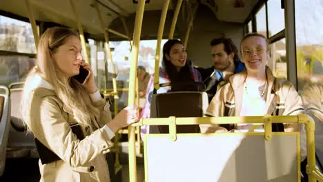 Young woman talking on the phone in the bus